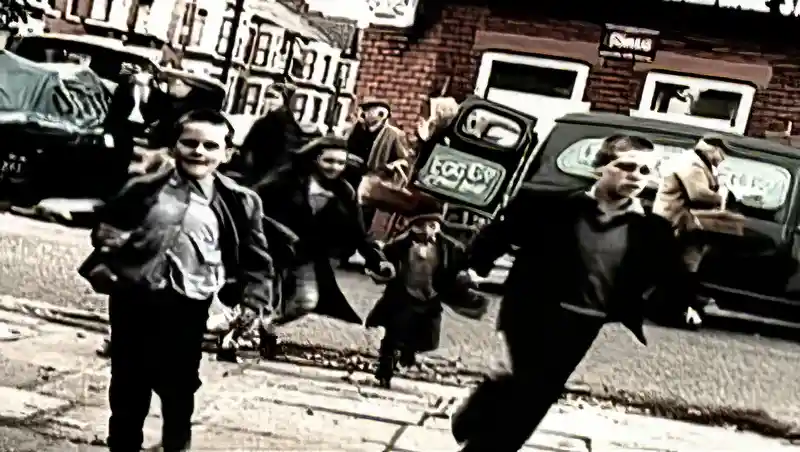 Children running in the busy street scene in the "Free As A Bird" video, with a delivery van in the background