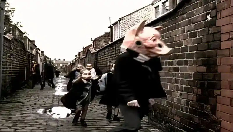 Children wearing pig masks running down a back street in the Free As A Bird video